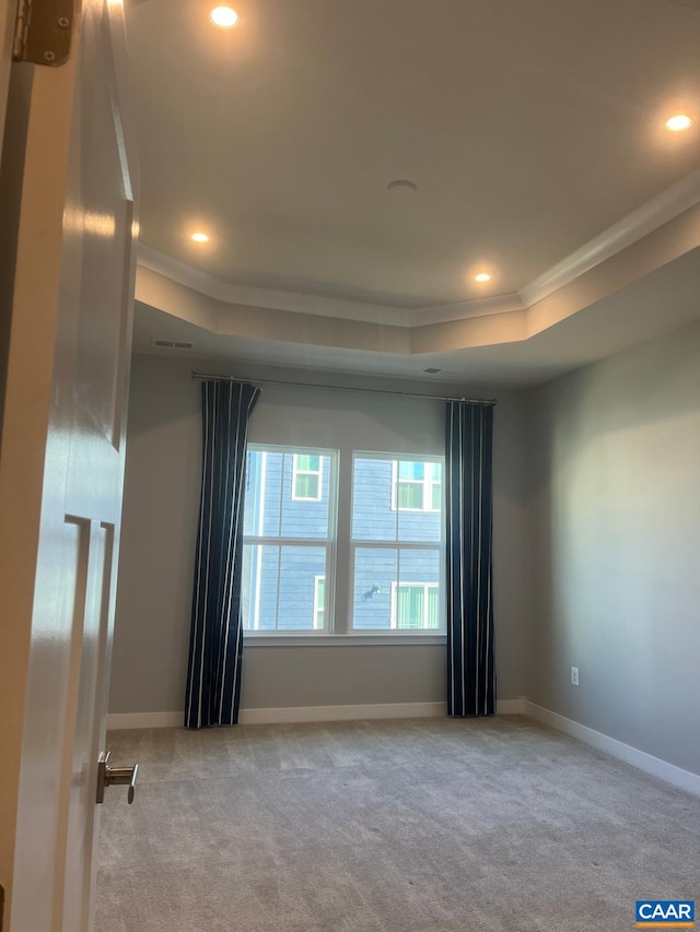 spare room featuring a tray ceiling, carpet, ornamental molding, and recessed lighting
