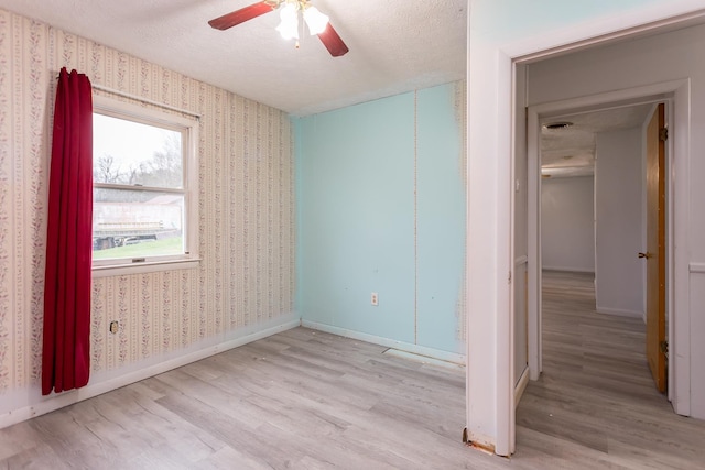 1627 Barbershop Rd, Edinburg, VA 22824 - unfurnished bedroom with wallpapered walls, light wood-type flooring, and a textured ceiling
