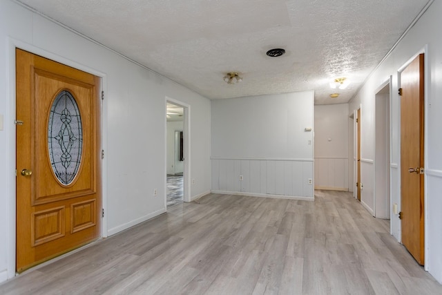 1627 Barbershop Rd, Edinburg, VA 22824 - foyer with a wainscoted wall, a textured ceiling, and light wood-style flooring