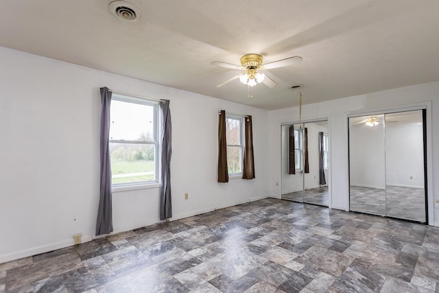 1627 Barbershop Rd, Edinburg, VA 22824 - unfurnished bedroom with baseboards, stone finish flooring, ceiling fan, visible vents, and multiple closets