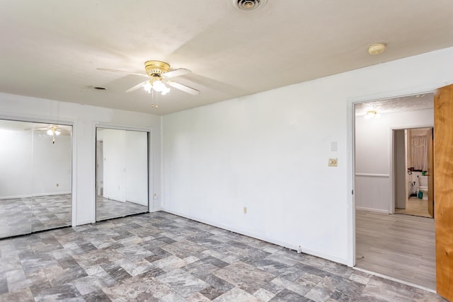 1627 Barbershop Rd, Edinburg, VA 22824 - unfurnished bedroom featuring stone finish floor, multiple closets, visible vents, ceiling fan, and baseboards