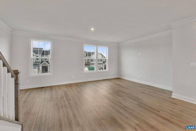 unfurnished living room featuring crown molding, light wood finished floors, stairway, and baseboards