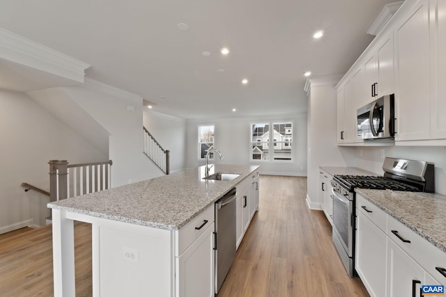 kitchen with appliances with stainless steel finishes, a sink, crown molding, recessed lighting, and white cabinetry