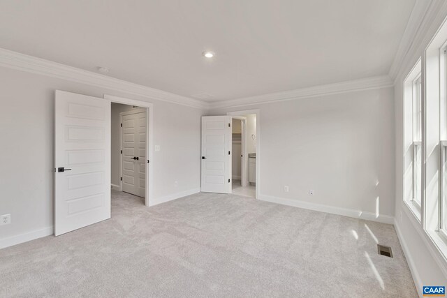 unfurnished bedroom with crown molding, light carpet, and baseboards