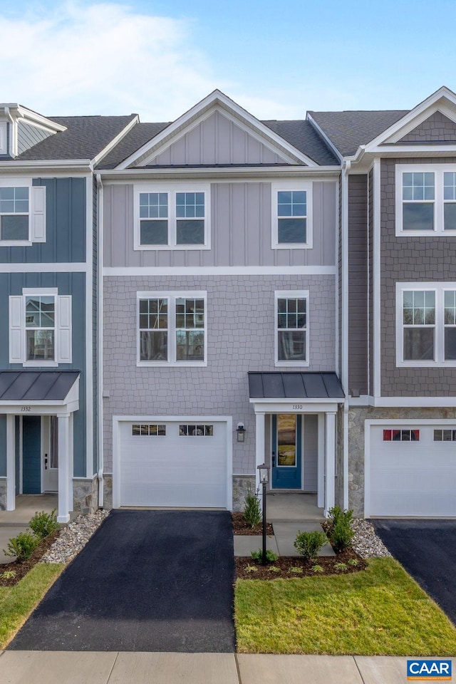 townhome / multi-family property featuring board and batten siding, driveway, and a garage