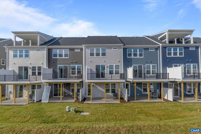 rear view of property with a lawn, central AC unit, and a patio