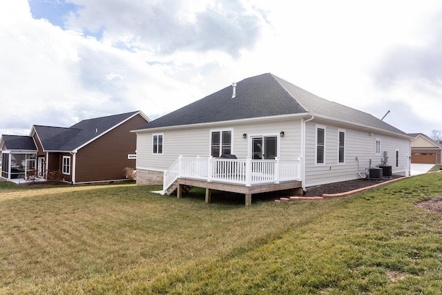 rear view of property featuring central AC unit, a deck, and a lawn