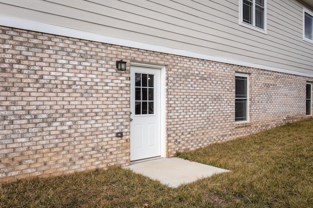 doorway to property featuring a lawn