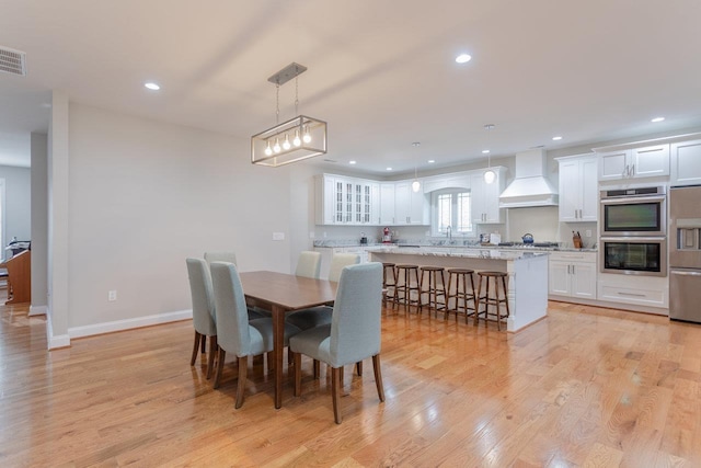 dining space with sink and light hardwood / wood-style flooring