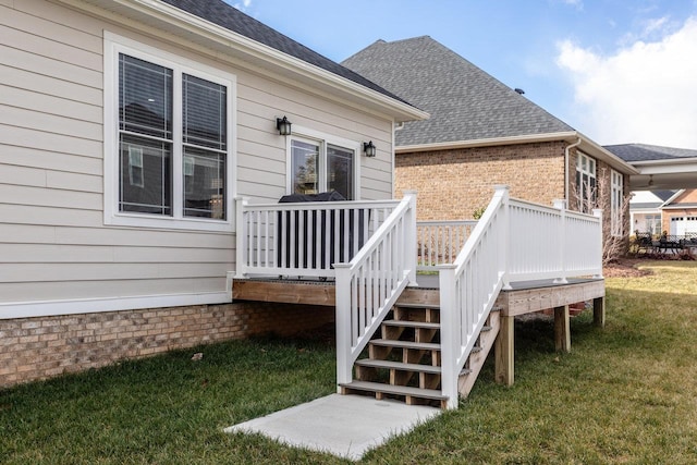 rear view of property featuring a wooden deck and a yard