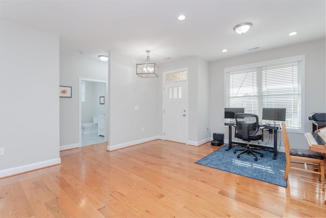 office area featuring light hardwood / wood-style floors and a chandelier