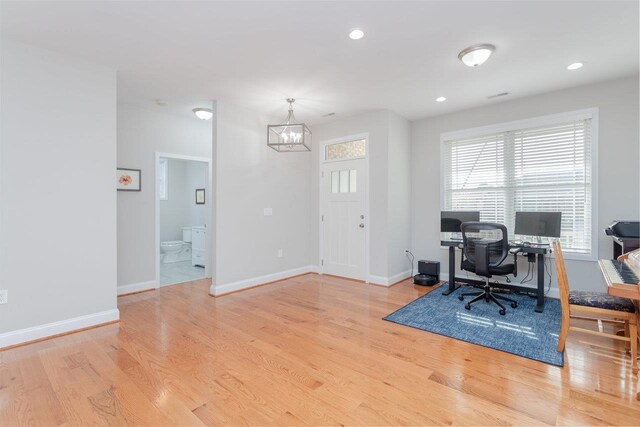 office area featuring light hardwood / wood-style floors and a chandelier