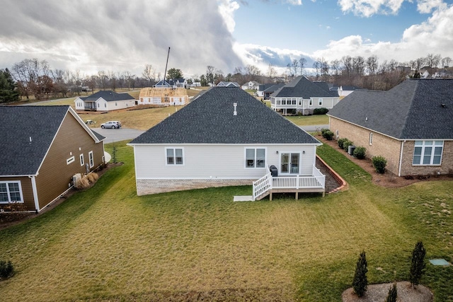 rear view of house with a wooden deck and a yard