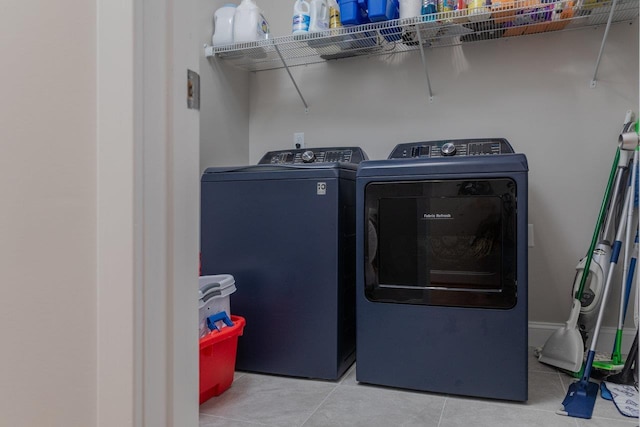 clothes washing area featuring washing machine and clothes dryer and light tile patterned flooring