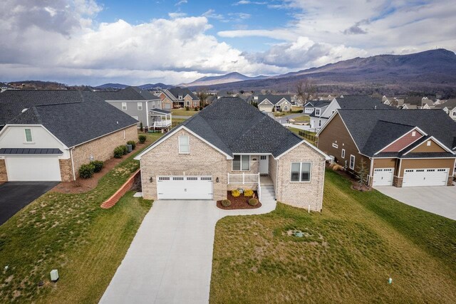 view of front of home with a garage, a mountain view, and a front yard