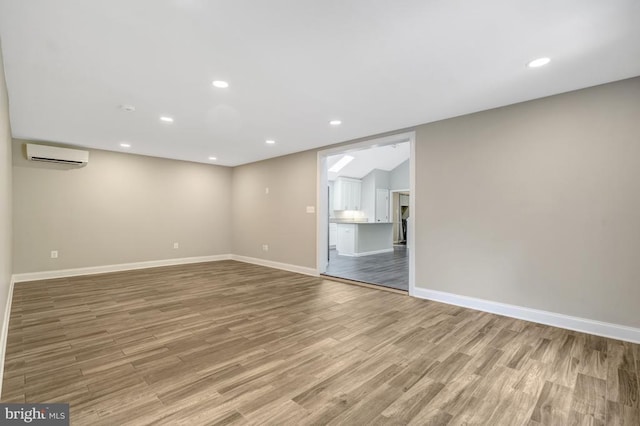  - spare room with recessed lighting, a wall mounted AC, baseboards, and wood finished floors
