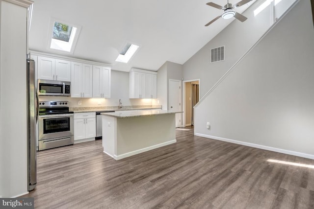  - kitchen featuring visible vents, white cabinetry, high vaulted ceiling, stainless steel appliances, and a skylight
