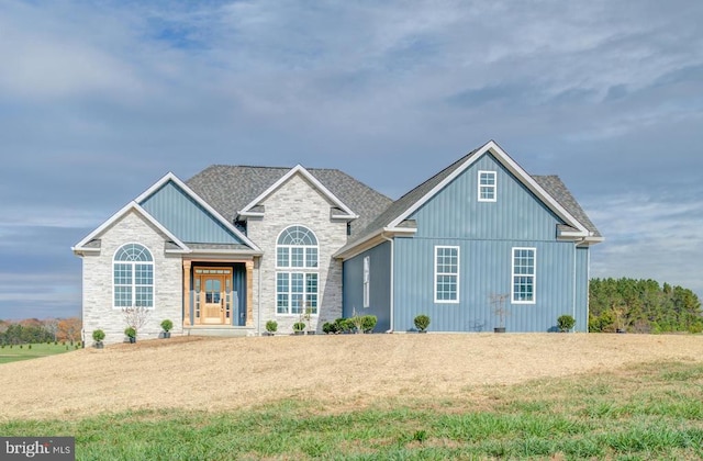 view of front of property featuring a front lawn and a shingled roof