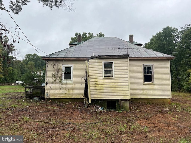 rear view of property featuring a chimney
