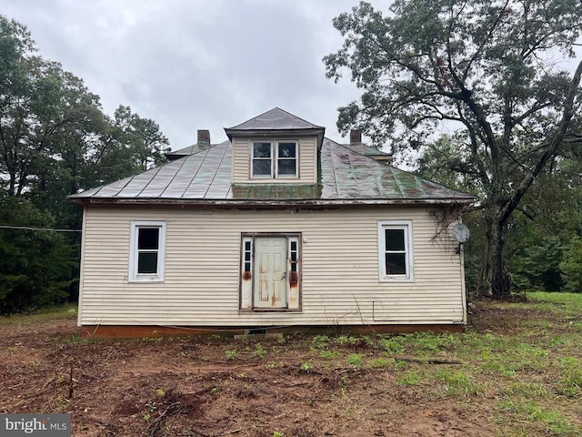 rear view of property with metal roof and a chimney