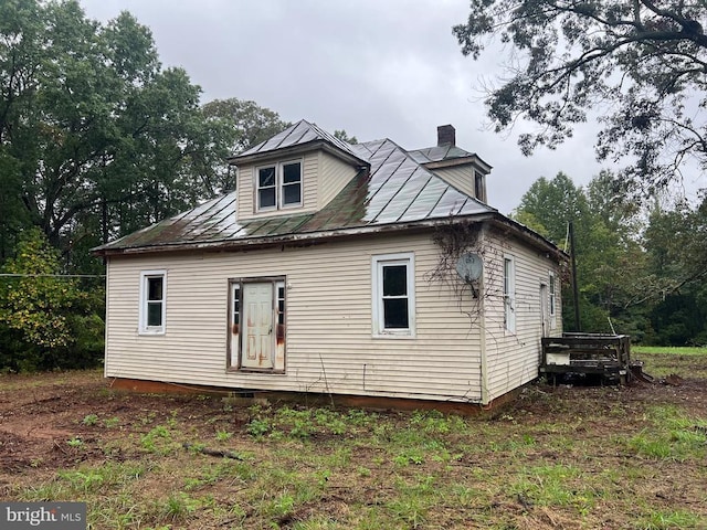 rear view of property featuring a chimney