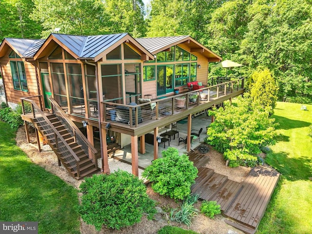103 Castleton Ford Rd, Castleton, VA 22716 - back of house featuring a standing seam roof, a deck, metal roof, a lawn, and stairs