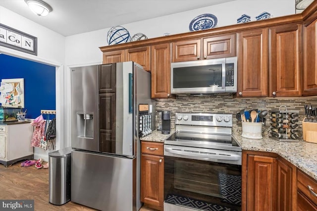 1218 Heatherbrook Ct, Fredericksburg, VA 22407 - kitchen featuring stainless steel appliances, tasteful backsplash, brown cabinetry, and light stone countertops