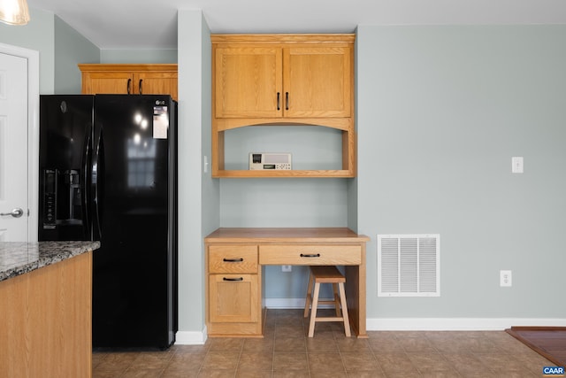 kitchen featuring black fridge and baseboards