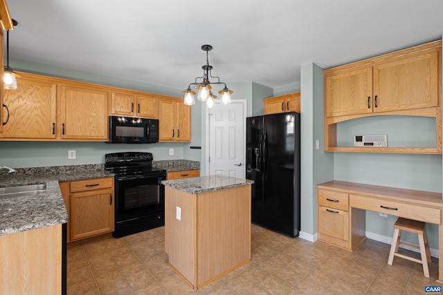 kitchen with a sink, built in desk, black appliances, a center island, and stone counters
