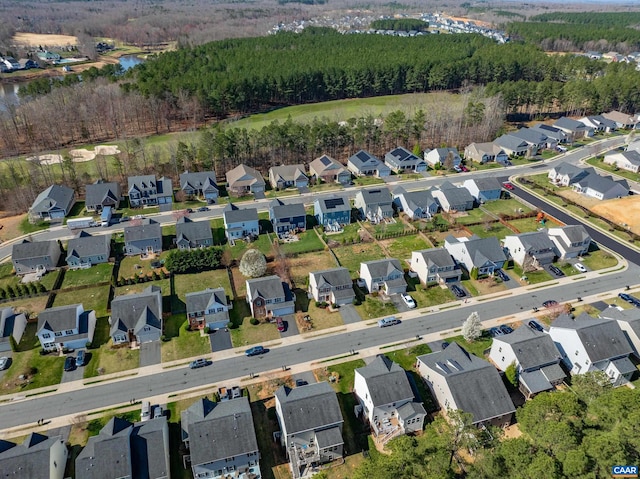 aerial overview of property's location with nearby suburban area and a heavily wooded area