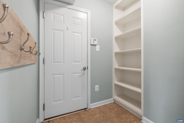 doorway featuring baseboards and tile patterned floors