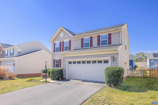 traditional-style house featuring a front lawn, aphalt driveway, an attached garage, and fence