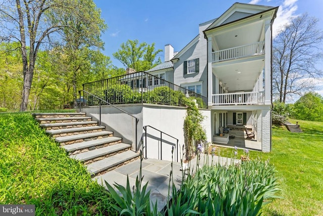  - rear view of house featuring a balcony, stairs, a yard, and a patio