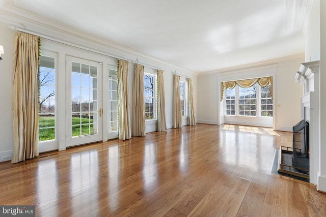  - unfurnished living room featuring crown molding, a fireplace, wood finished floors, and baseboards