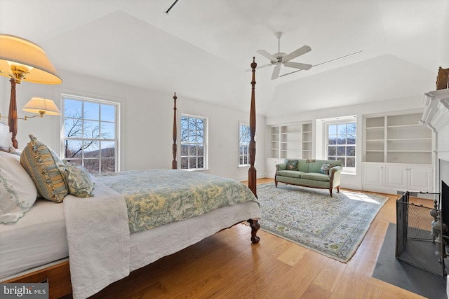  - bedroom featuring lofted ceiling, wood finished floors, multiple windows, and a ceiling fan