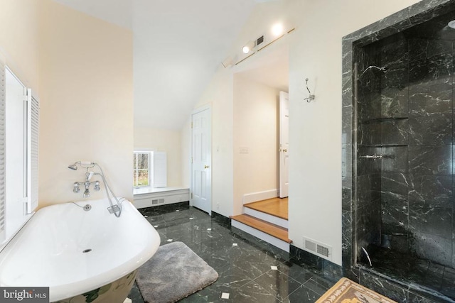  - full bathroom featuring marble tiled flooring, a freestanding bath, and a tile shower
