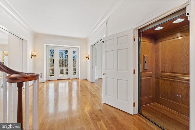  - hallway featuring elevator, crown molding, and light wood-type flooring