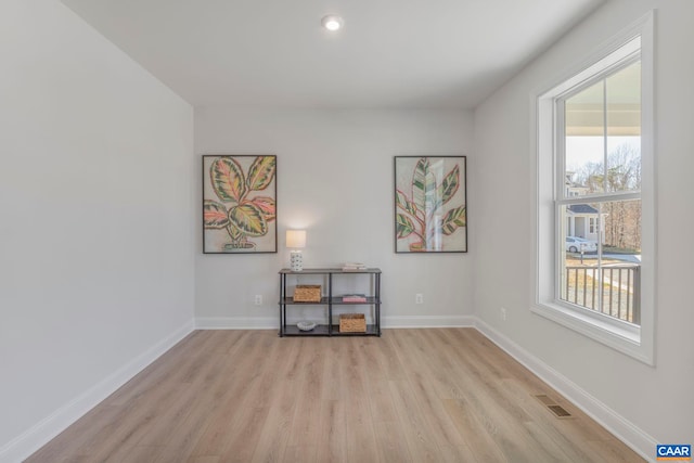 interior space with baseboards, light wood-style flooring, and visible vents