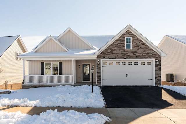 view of front facade featuring cooling unit, a garage, and covered porch