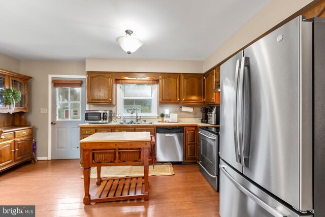 11404 Warner Dr, Fredericksburg, VA 22407 - kitchen with appliances with stainless steel finishes, a sink, light countertops, wood finished floors, and brown cabinetry