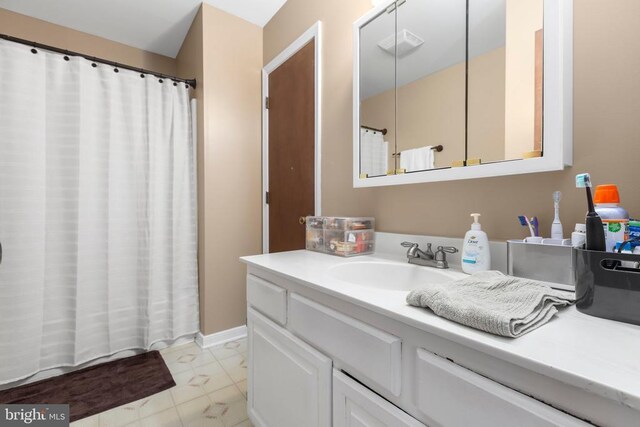11404 Warner Dr, Fredericksburg, VA 22407 - full bathroom with marble look tiles, vanity, and a shower with curtain