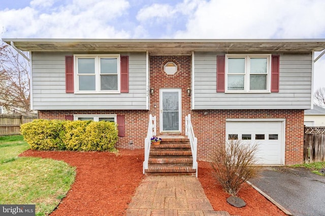 11404 Warner Dr, Fredericksburg, VA 22407 - raised ranch with fence, an attached garage, asphalt driveway, and brick siding