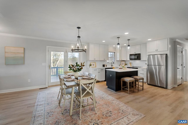 912 Shores Rd, Palmyra, VA 22963 - dining space with light wood finished floors, an inviting chandelier, baseboards, ornamental molding, and recessed lighting
