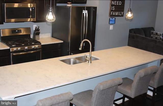 2437 Drake Ln, Fredericksburg, VA 22408 - kitchen featuring appliances with stainless steel finishes, a sink, light stone counters, and hanging light fixtures