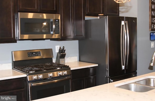 2437 Drake Ln, Fredericksburg, VA 22408 - kitchen featuring stainless steel appliances, a sink, dark brown cabinetry, and light stone countertops