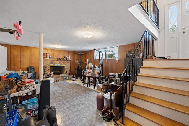 708 Woodside Ln, Waynesboro, VA 22980 - living room with wood walls, stairway, a fireplace, a textured ceiling, and tile patterned floors