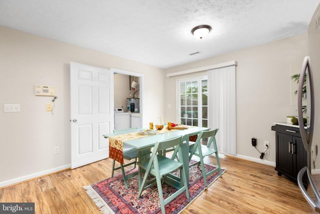 2912 Broyhill Ct, Fredericksburg, VA 22408 - dining area featuring washer / dryer, light wood finished floors, baseboards, and a textured ceiling