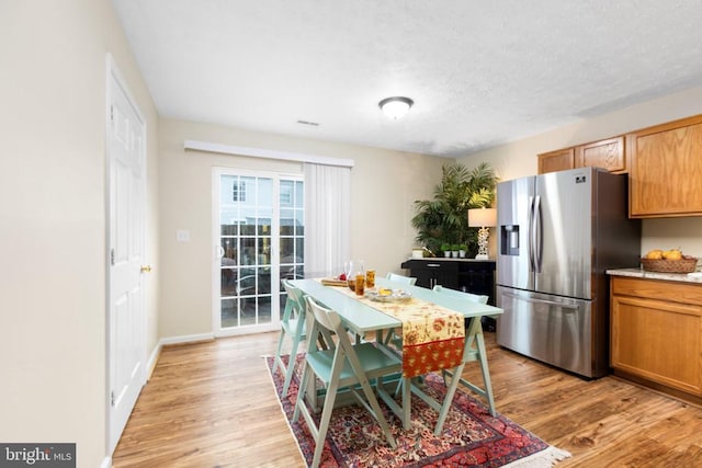 2912 Broyhill Ct, Fredericksburg, VA 22408 - kitchen with stainless steel fridge with ice dispenser, light wood-type flooring, light countertops, a textured ceiling, and baseboards