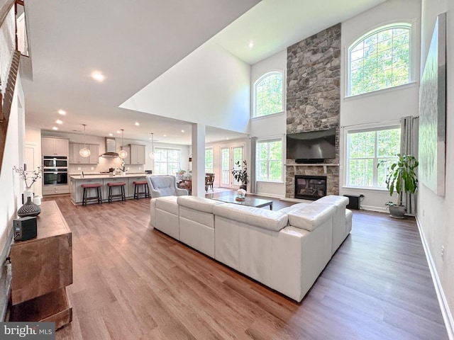 8525 Laroque Run Dr, Fredericksburg, VA 22407 - living room with a fireplace, plenty of natural light, light wood finished floors, a high ceiling, and baseboards