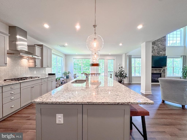 8525 Laroque Run Dr, Fredericksburg, VA 22407 - kitchen featuring wall chimney range hood, stainless steel gas stovetop, a sink, dark wood-style flooring, and healthy amount of natural light